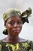 a beautiful woman looks at the camera, wearing her Ivory Coast style with matching hat